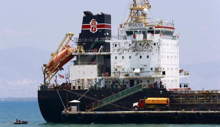 In this April 16 2019 photo a ship fills up on fuel from a tanker truck on the Thor terminal in Carrefour a district of Port au Prince Haiti.